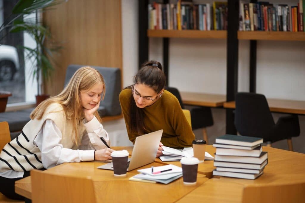 Two students studying together in a library